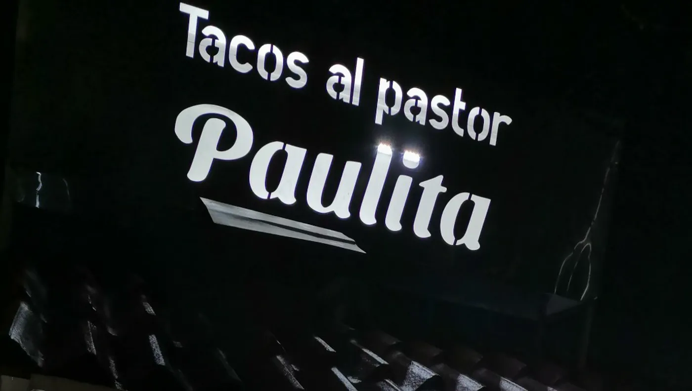 Letrero luminoso del local que dice Tacos al pastor Paulita